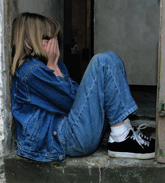 A girl holding her face in her hands.