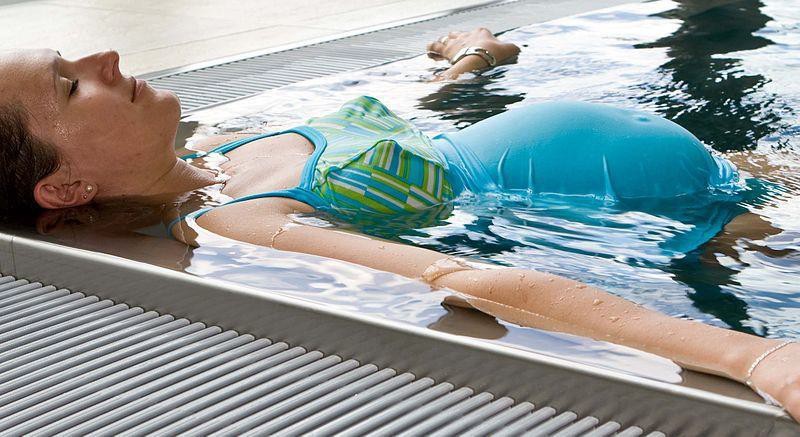 A pregnant woman relaxing in a tub.