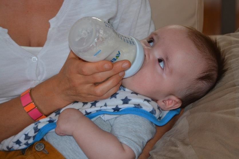 An infant looking up at the person feeding them.