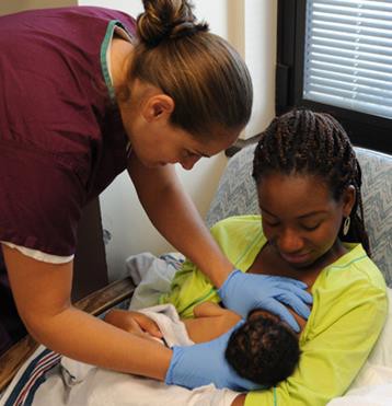 A nurse helping a new mother to breastfeed.