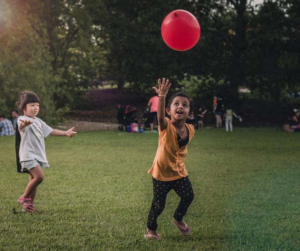 Two young children playing in the Singapore Botanic Gardens