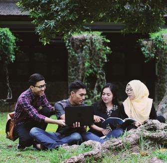 People sitting on the grass reading.