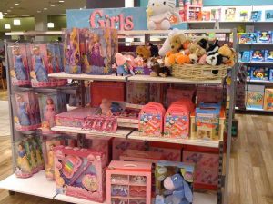 Store shelves filled with pink and purple colors and girls’ toys